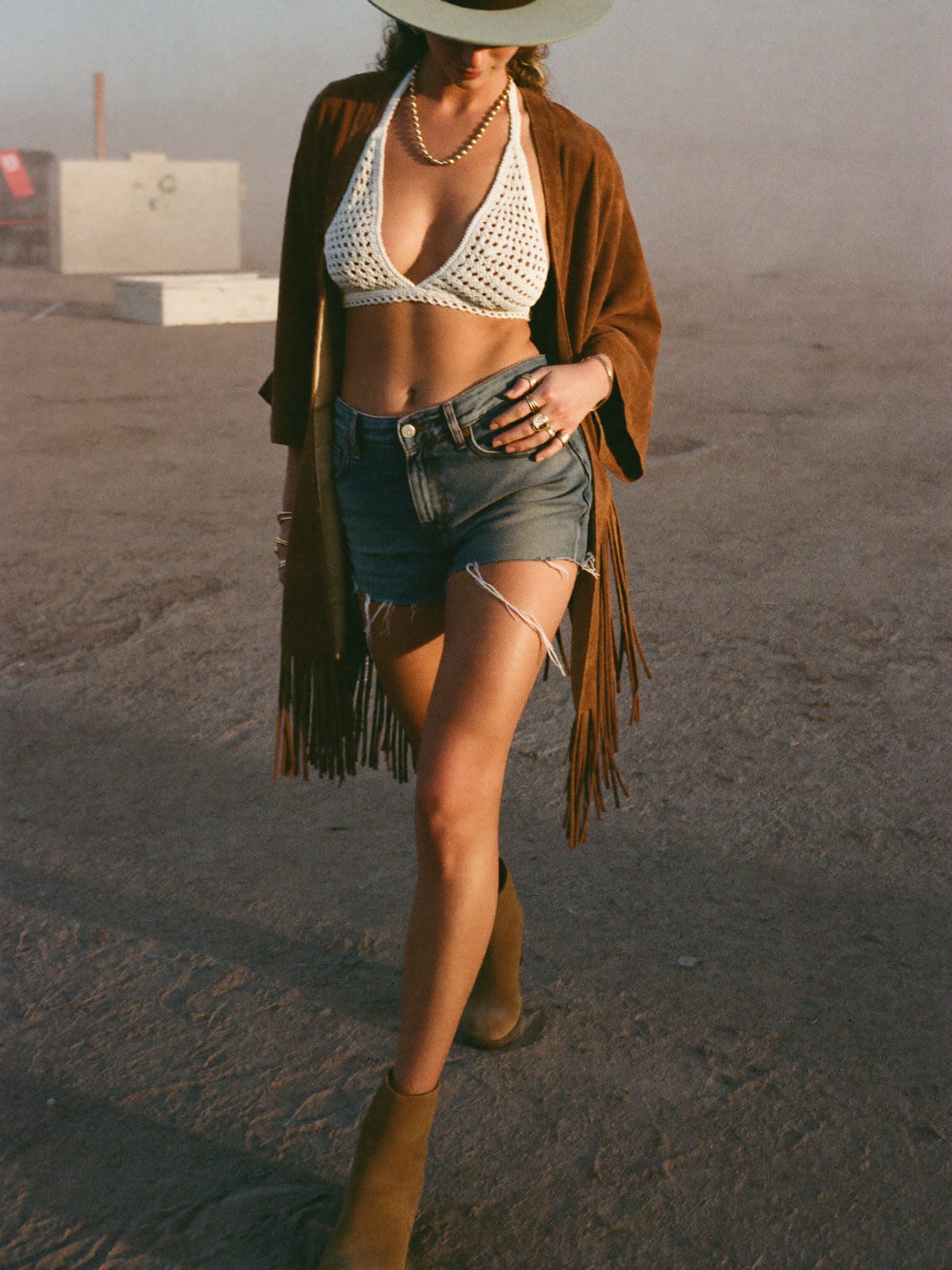 Desert Boho outfit for Coachella: crochet halter or bralette, high-rise denim cut-offs, fringed suede or kimono layer
