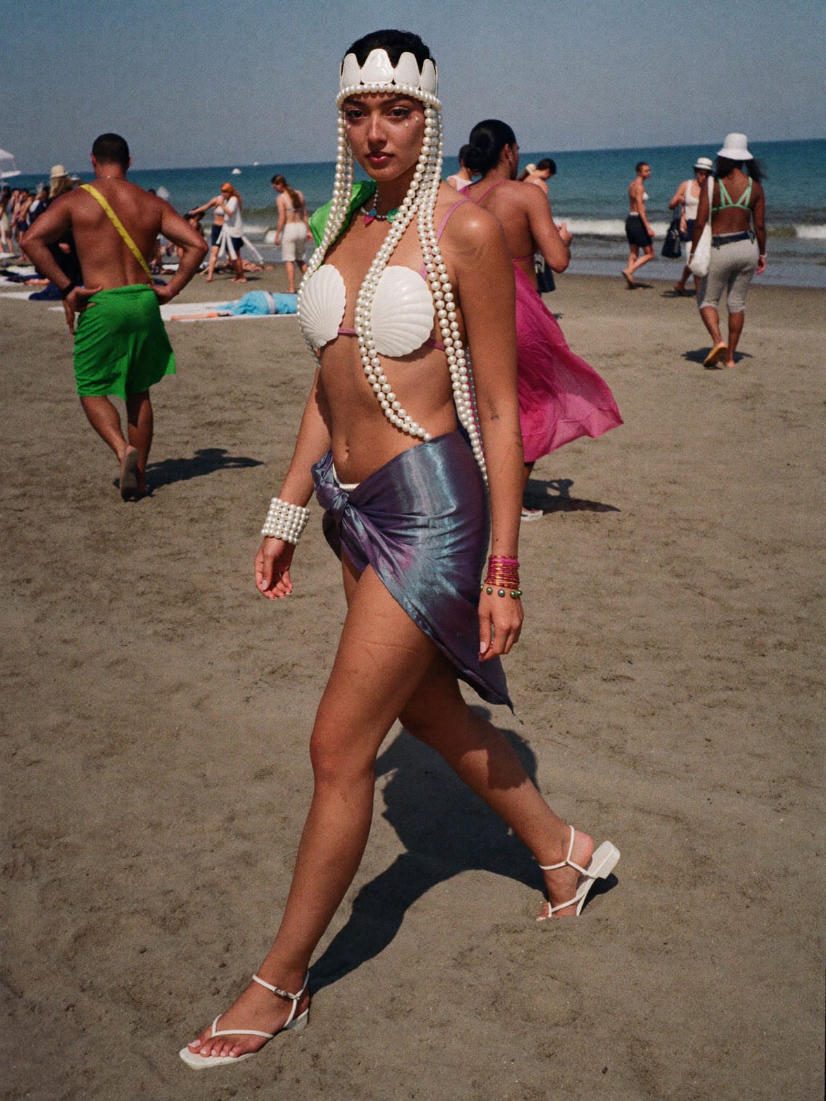 Mermaidcore outfit for Gnaoua World Music Festival: shell or pearl-trim top, iridescent sarong or skirt, strappy flat sandals